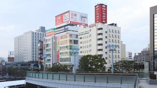 a city skyline with tall buildings and a bridge at Koriyama - Hotel / Vacation STAY 45300 in Koriyama