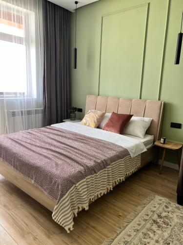 a bedroom with a large bed with pillows on it at Green Plaza-SeaView in Aktau