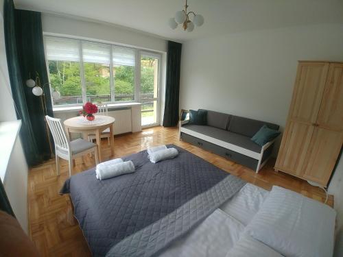 a bedroom with a bed and a couch and a table at DOM POD SOKOLICĄ in Będkowice