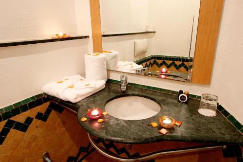 a bathroom with a sink and a mirror at Hôtel Fnideq Senator in Fnidek