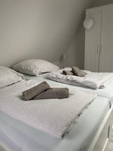 two white beds with towels on top of them at Gästehaus Bönebüttel-nahe Neumünster Netflix in Bönebüttel