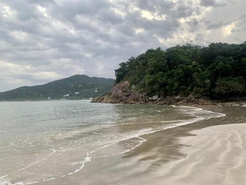 a beach with the ocean and a mountain at Hotel The Green Ecologic in Guarujá