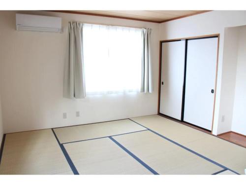um quarto vazio com uma grande janela e uma porta em Glamp House DAISEN Garden - Vacation STAY 97255v em Yonago