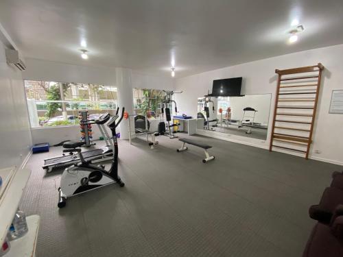 a gym with several treadmills and machines in a room at Guarujá praia das Pitangueiras a 50 metros do mar in Guarujá