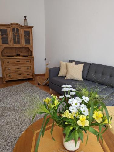 un soggiorno con divano e tavolo con fiori di Ursula a Schneeberg