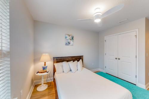 1 dormitorio blanco con 1 cama y ventilador de techo en 1944 Pointe Dr en Panama City Beach