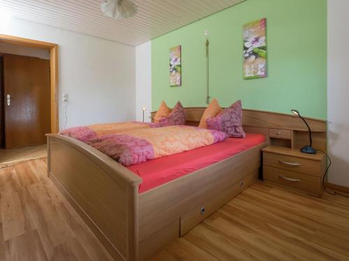 a bedroom with a large bed with a red blanket at Quiet apartment in Neukirch with private terrace in Furtwangen