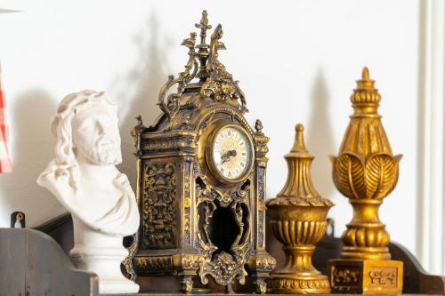 an ornate clock sitting on a table with a statue at Villa Daringer in Mayrhofen