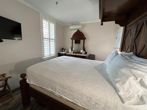 a bedroom with a large bed and a mirror at Elaine's Cape May Boutique Hotel in Cape May
