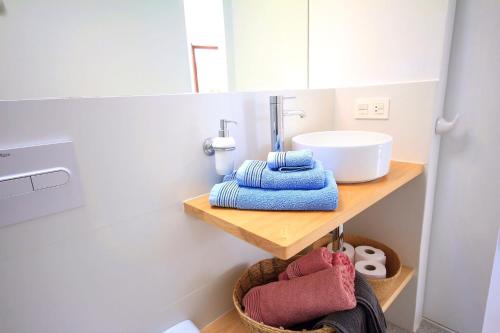 uma casa de banho com um lavatório e toalhas numa prateleira em Unique, Stylish & Calm Los Peces by the Sea em Costa Teguise