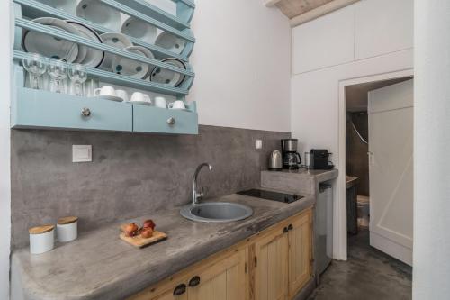 uma cozinha com um lavatório e uma bancada em Venia's Guesthouse em Pollonia