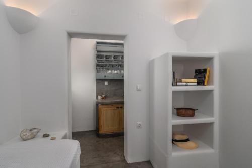 a bedroom with white walls and a room with a closet at Venia's Guesthouse in Pollonia