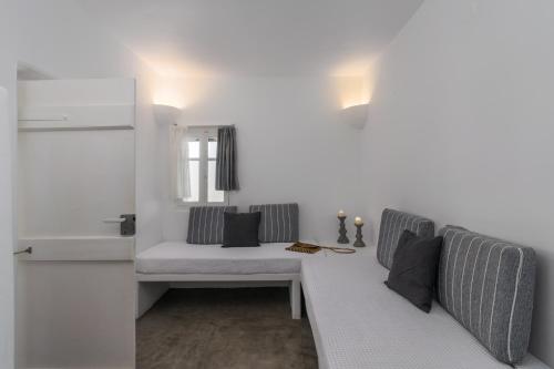 a white living room with a couch and a window at Venia's Guesthouse in Pollonia