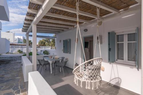 a patio with swing chairs and a table at Venia's Guesthouse in Pollonia