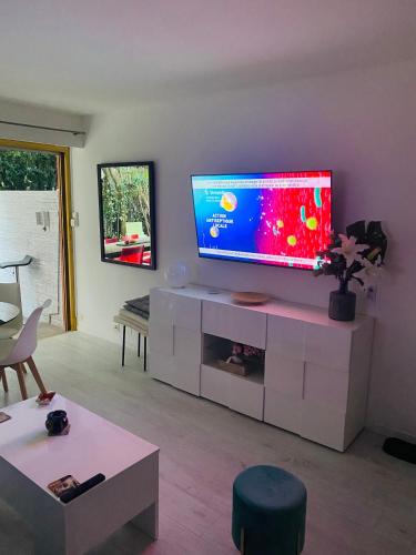 - un salon avec une télévision à écran plat dans un centre de divertissement blanc dans l'établissement 3 pièces terrasse, jardin, à Cannes