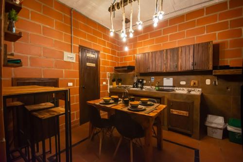a kitchen with an orange brick wall and a table at Hotel Le Chateau Guatape in Guatapé