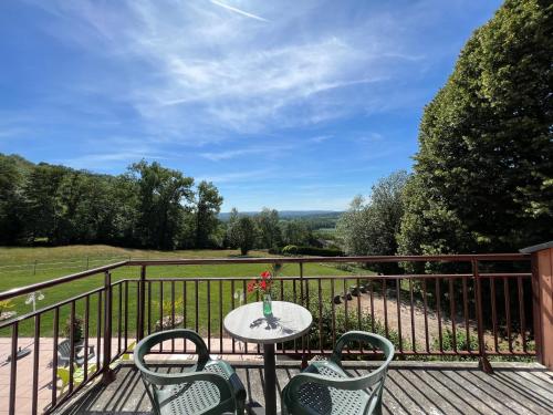 a patio with a table and chairs on a balcony at Hôtel les Bergeronnettes in Champagneux