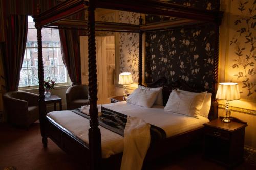 a bedroom with a canopy bed and a window at Milford Hall Hotel & Spa in Salisbury