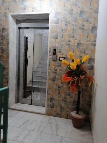 a bathroom with a mirror and a vase with flowers at Yaso Roof & Apartments in Amman
