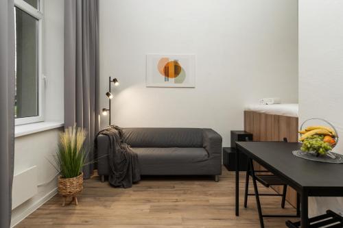 Air Apartment 109 في فيلنيوس: غرفة معيشة مع أريكة وطاولة