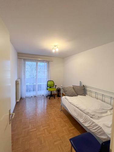 a bedroom with a bed and a chair and a window at Schöne grosse Attika-Wohnung im Zentrum von Vaduz inkl. Parkplatz in Vaduz