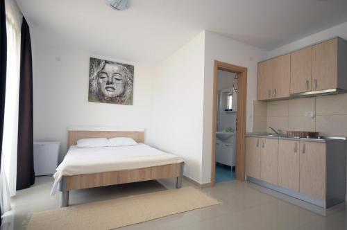 ein Schlafzimmer mit einem Bett und einer Küche darin in der Unterkunft Apartments Vila Anastasia in Budva
