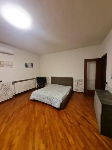 a bedroom with a bed and a wooden floor at Affittacamere airport orio Bergamo in Orio al Serio