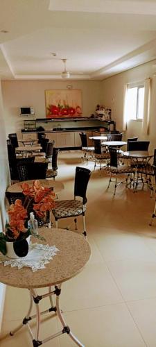 una stanza con tavoli e sedie e un pianoforte di HOTEL PLAZA PONTES e LACERDA a Pontes e Lacerda