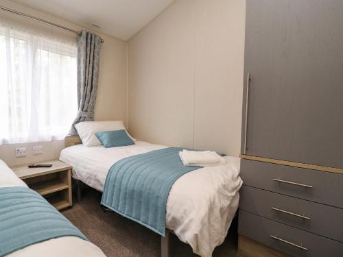 een kleine slaapkamer met 2 bedden en een raam bij Fountain View in Carnforth