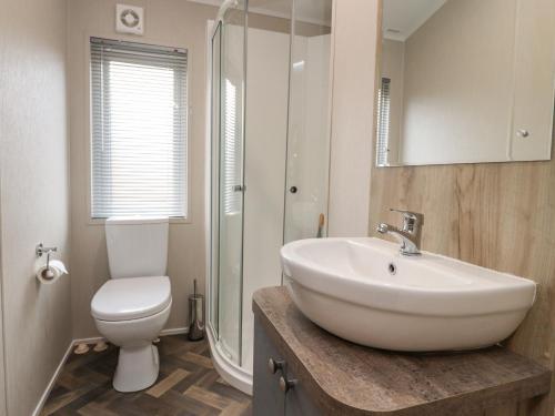 een badkamer met een witte wastafel en een toilet bij Fountain View in Carnforth