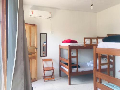 a room with three bunk beds in a room at Natal Chalés Nova Caraiva in Caraíva