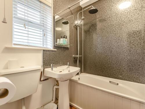 a bathroom with a sink and a toilet and a tub at The Boars Head Pub in Bishops Castle