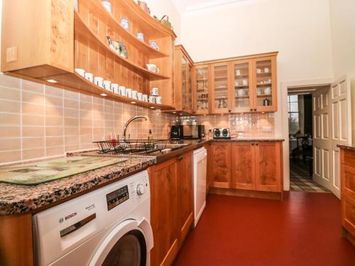 a kitchen with a washer and dryer in it at The Preston Tower Apartment - Fyvie Castle in Turriff