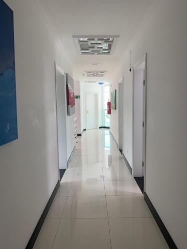 a hallway of an office building with white walls and white floors at Hotel The Green Ecologic in Guarujá