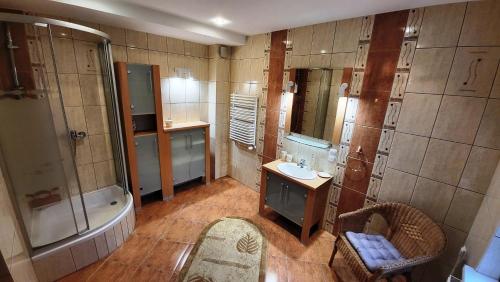 bagno con vasca, lavandino e doccia di Apartament ANGELO a Głogówek