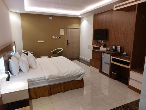a hotel room with a bed and a television at فندق تايا - Taya Hotel in Sūq al Aḩad