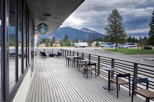 a balcony with tables and chairs and a clock on a building at Marmot Lodge Jasper in Jasper