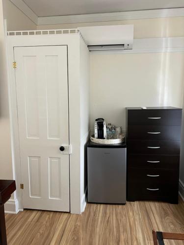 a kitchen with a white door and a black cabinet at Elaine's Cape May Boutique Hotel in Cape May