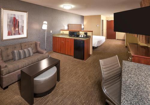 ein Hotelzimmer mit einem Sofa und einem Bett in der Unterkunft Silver Cloud Hotel - Portland in Portland