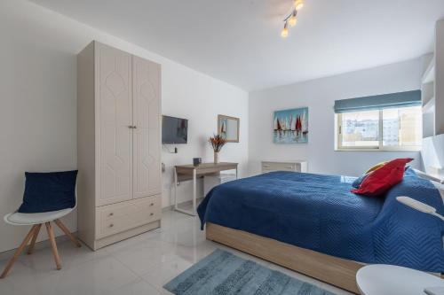 Schlafzimmer mit einem Bett, einem Schreibtisch und einem TV in der Unterkunft Sliema Bedrooms with ensuite bathrooms in Sliema