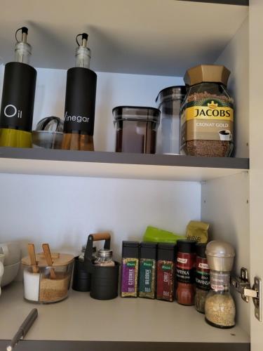 a kitchen pantry with food items on shelves at Luxury Copper Apartment in Łódź