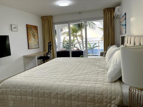 1 dormitorio con 1 cama grande y vistas al océano en Maho Beach Escape Luxe Studio Condo next to The Morgan Village, en Maho Reef