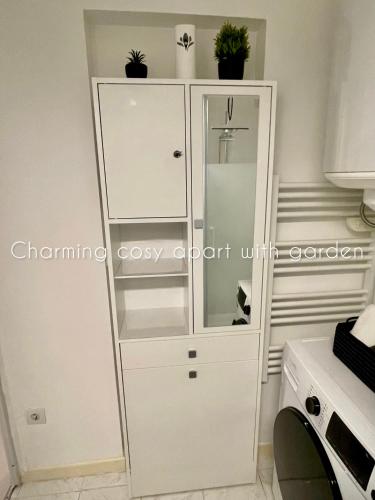 a white cabinet with plants on top of it at Charming cosy apart with garden free parking in Claye-Souilly