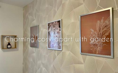 a wall with three pictures on a wall at Charming cosy apart with garden free parking in Claye-Souilly