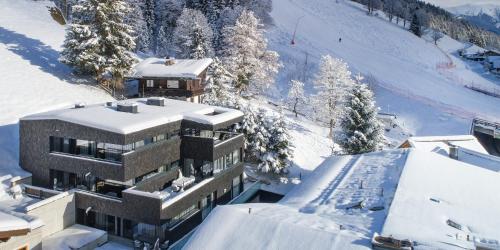 a building on top of a snow covered mountain at Sunny Ferienwohnungen Ski In - Ski Out - Self Check-in in Zell am See