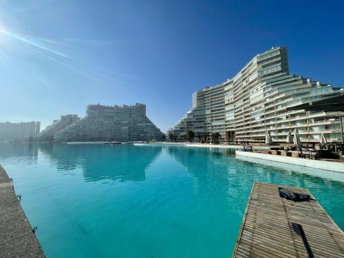 a large swimming pool next to two large buildings at San Alfonso Mágico in Algarrobo