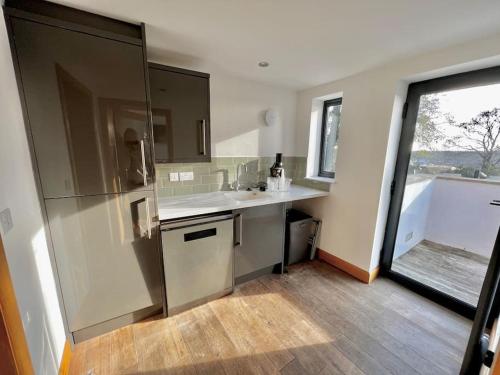a kitchen with a refrigerator and a sink and a window at Stylish 3 bed house with Castle views in Lincolnshire