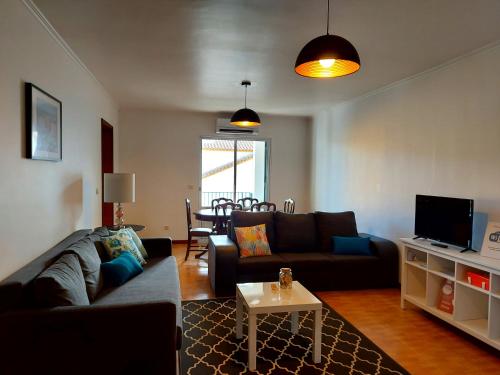 a living room with a couch and a table at Beach & Surf in Ribeira Grande