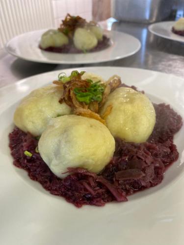 a plate of food with meat and potatoes on top at Hotel Formanka in Hustopeče