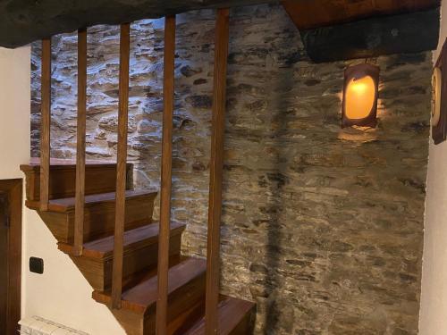 a staircase in a room with a stone wall at Casas Rurales TAReira en Taramundi in Taramundi